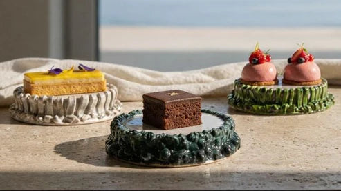Assorted desserts on decorative plates with a scenic background