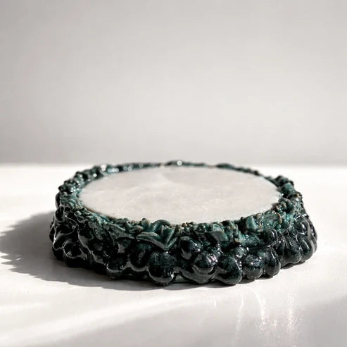 Black beaded bracelet on a white surface with a light gray background