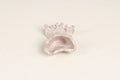 A small decorative shell-shaped dish or holder with a textured, glittery finish, shown on a plain off-white background.